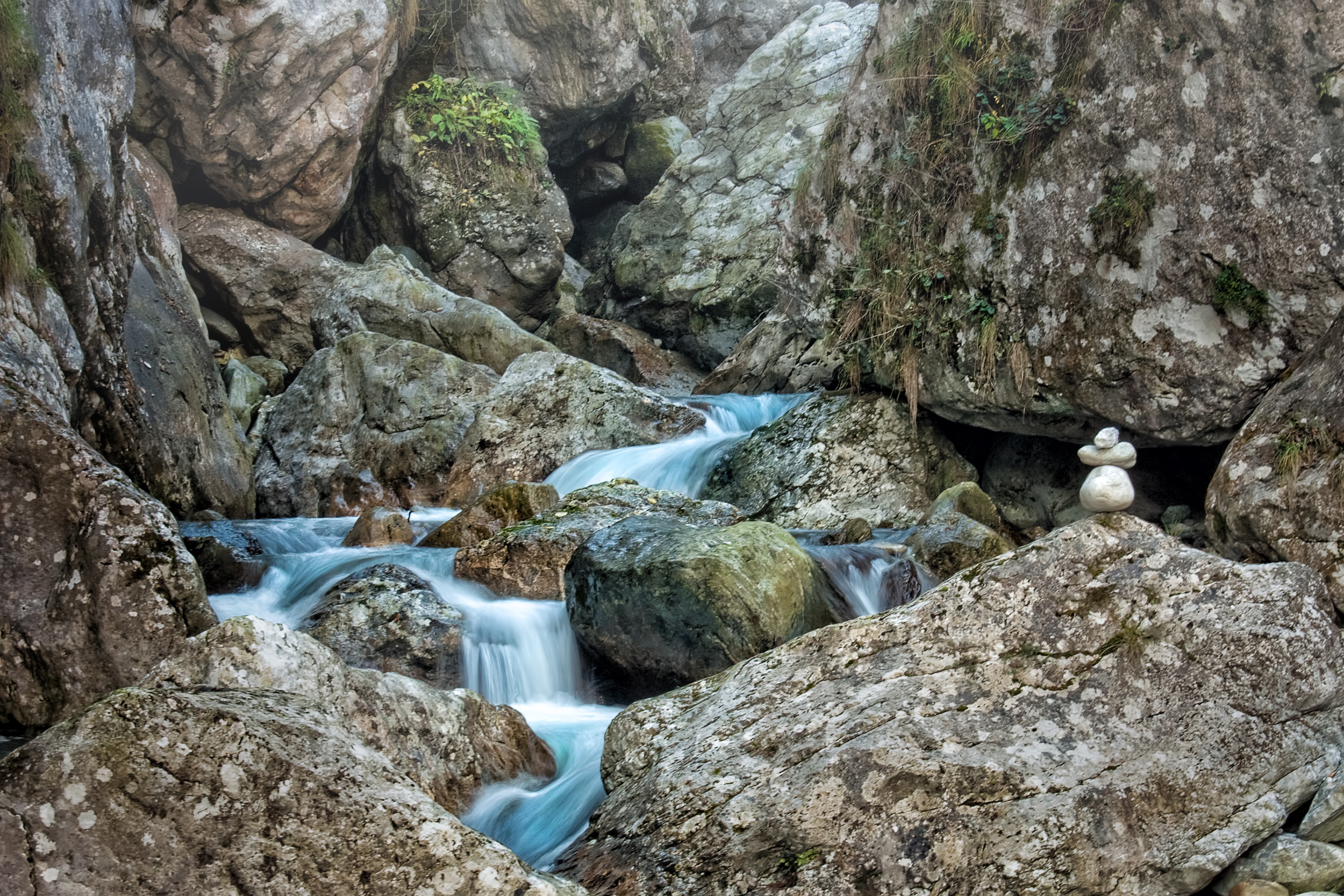 A set of rocks balanced amidst a rushing river.